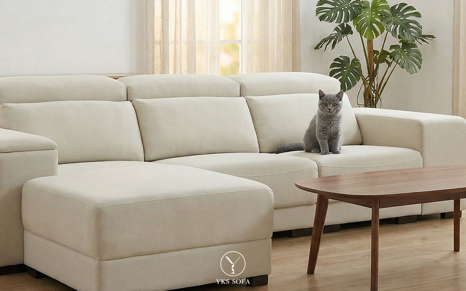 一隻貓坐在沙發上，呈現貓抓布沙發在日常使用情境下的耐抓與生活共存畫面